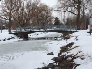 bridge over river snow on ground