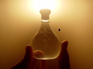 glass jar in a hand with light surrounding