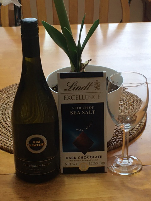 wine bottle, wine glass, wrapped bar of chocolate