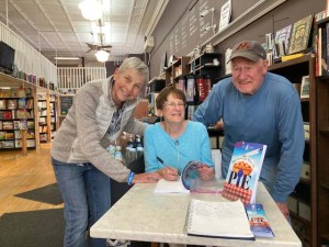 two women and a man in a bookstore