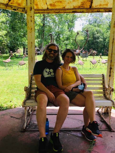 2 peopl sitting on a swing under a canopy