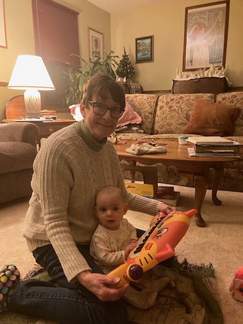 woman holding infant and musical keyboard