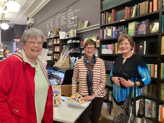 2 women standing in bookstore holding book To Die for Pickleball