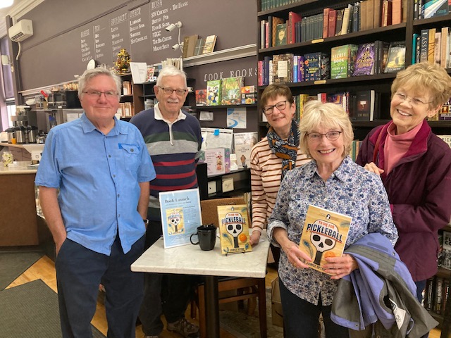 2 men and 3 women standing in bookstore holding book To Die for Pickleball
