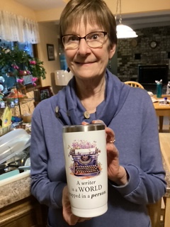 female in blue shirt holding a cup